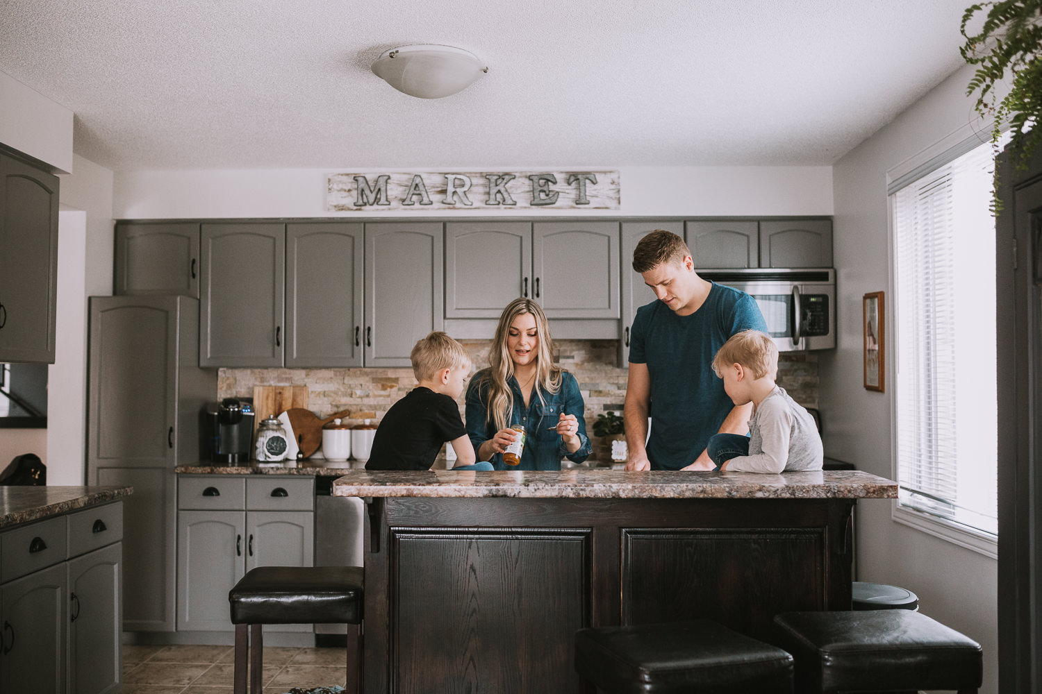 family of four with 2 young blonde boys preparing meal in kitchen - Markham lifestyle photography