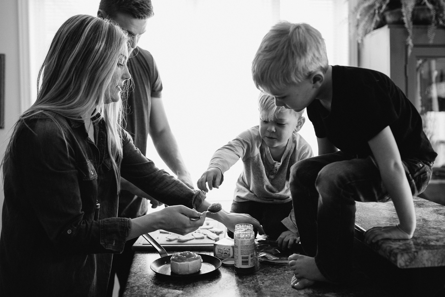 family of four with 2 young blonde boys preparing meal in kitchen - Stouffville lifestyle photography
