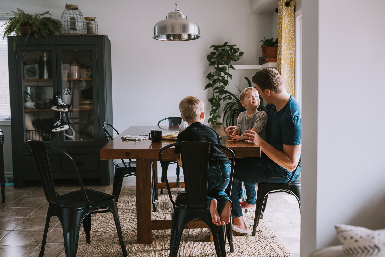 father and 2 young blonde sons sitting at kitchen table eating - Markham lifestyle photography