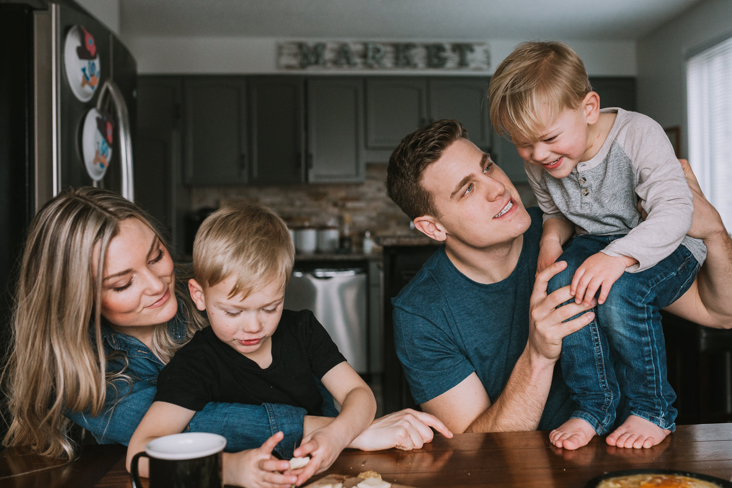 family of four with 2 young blonde brothers sitting at kitchen table - newmarket lifestyle photography