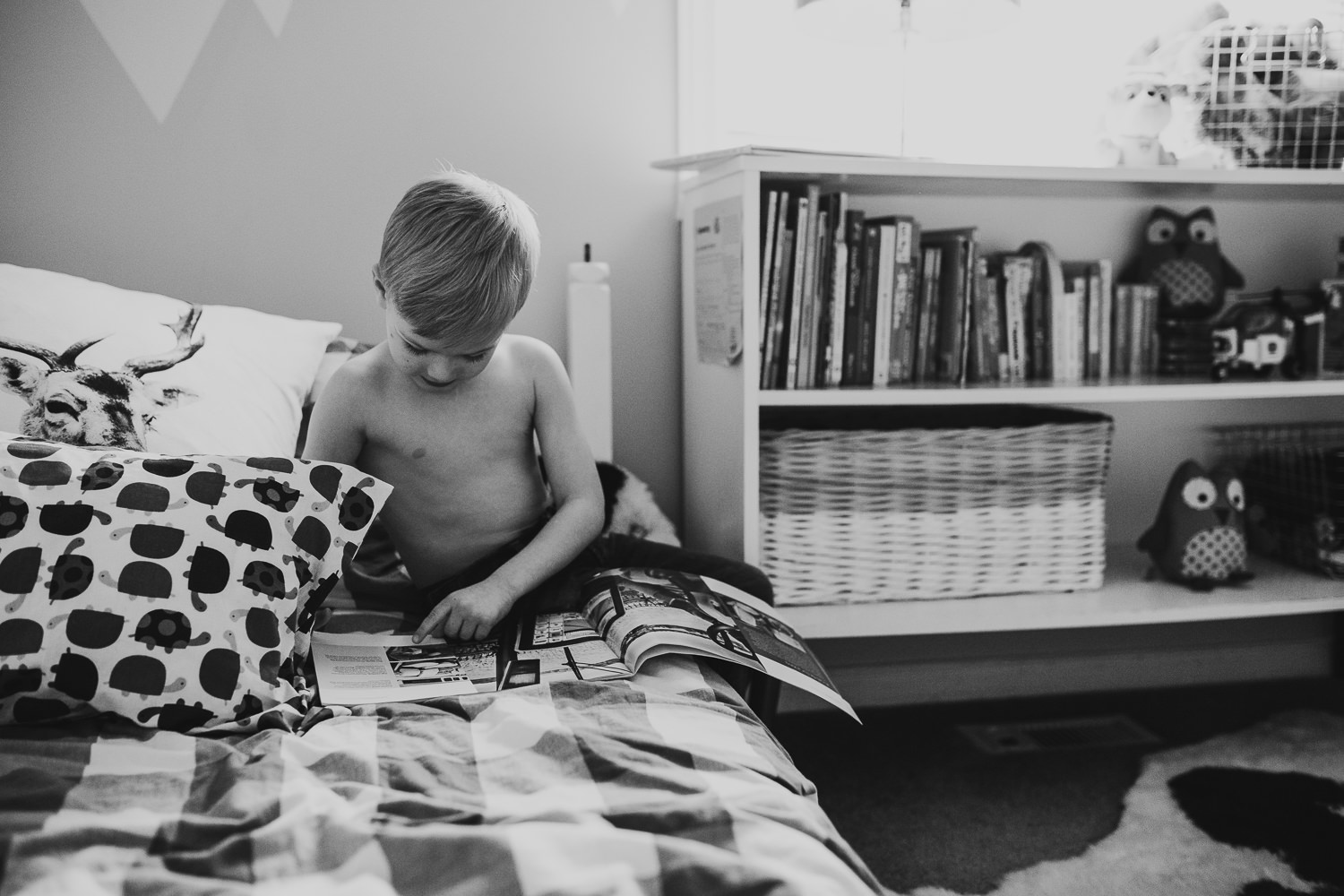 4 year old bot reads book while sitting on bed - Newmarket lifestyle photos