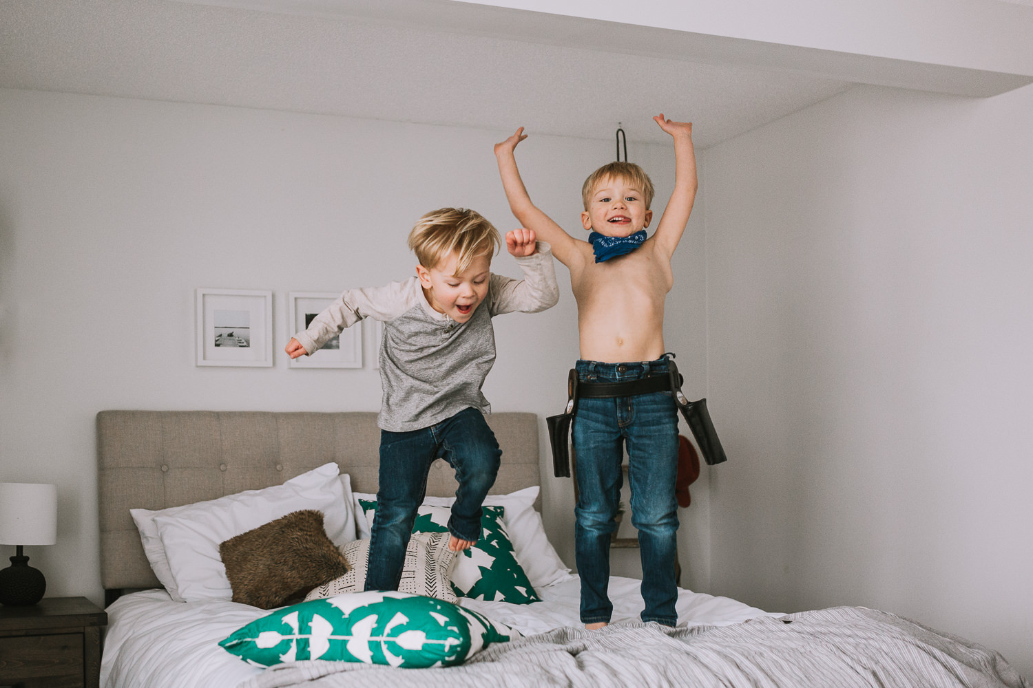 2 young blonde brothers jumping on parents bed - Newmarket lifestyle photography