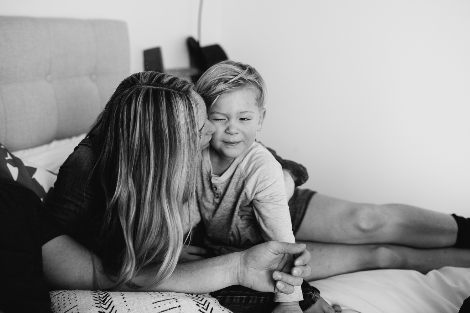 mom with long blonde hair kisses 3 year old son on cheek - Newmarket lifestyle photography