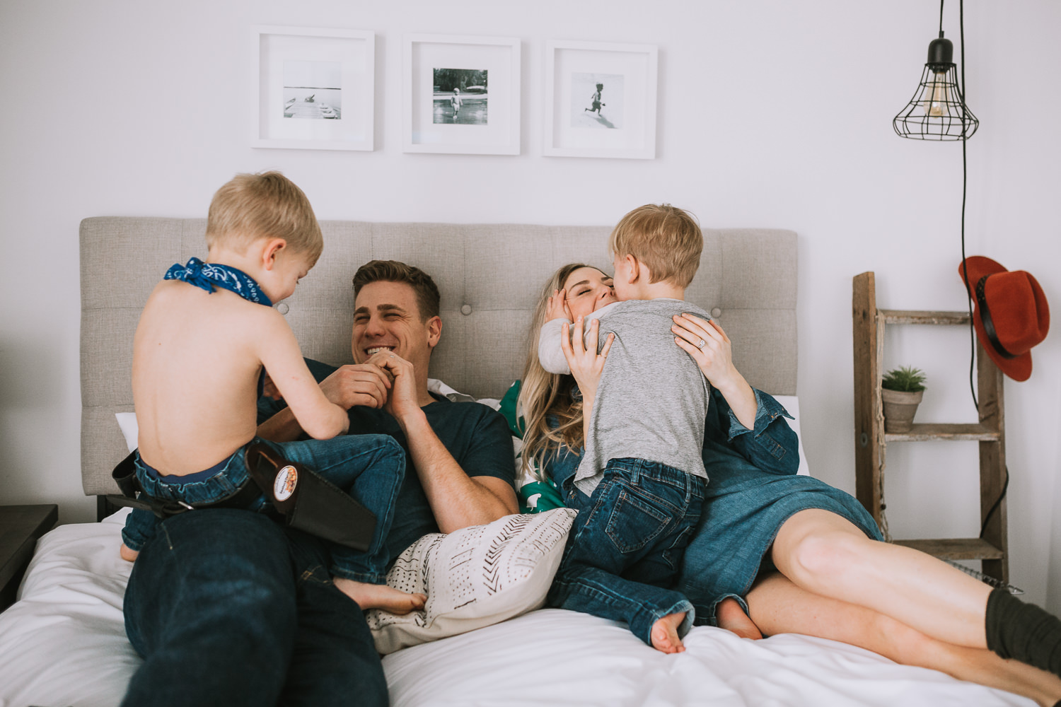 family of 4 with 2 blonde boys playing on parent's bed - Markham child photography