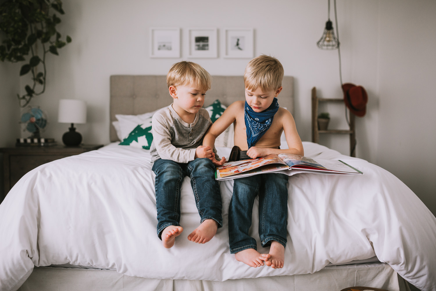 young blonde brothers reading story together on parents bed - Uxbridge child photography