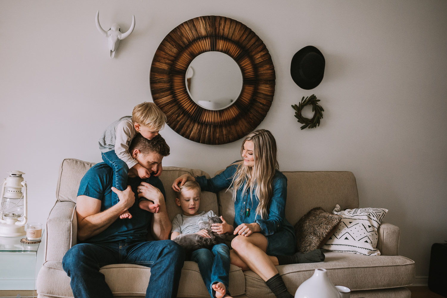 family of 4 with 2 blonde boys sitting on couch with pet cat - Uxbridge lifestyle photography