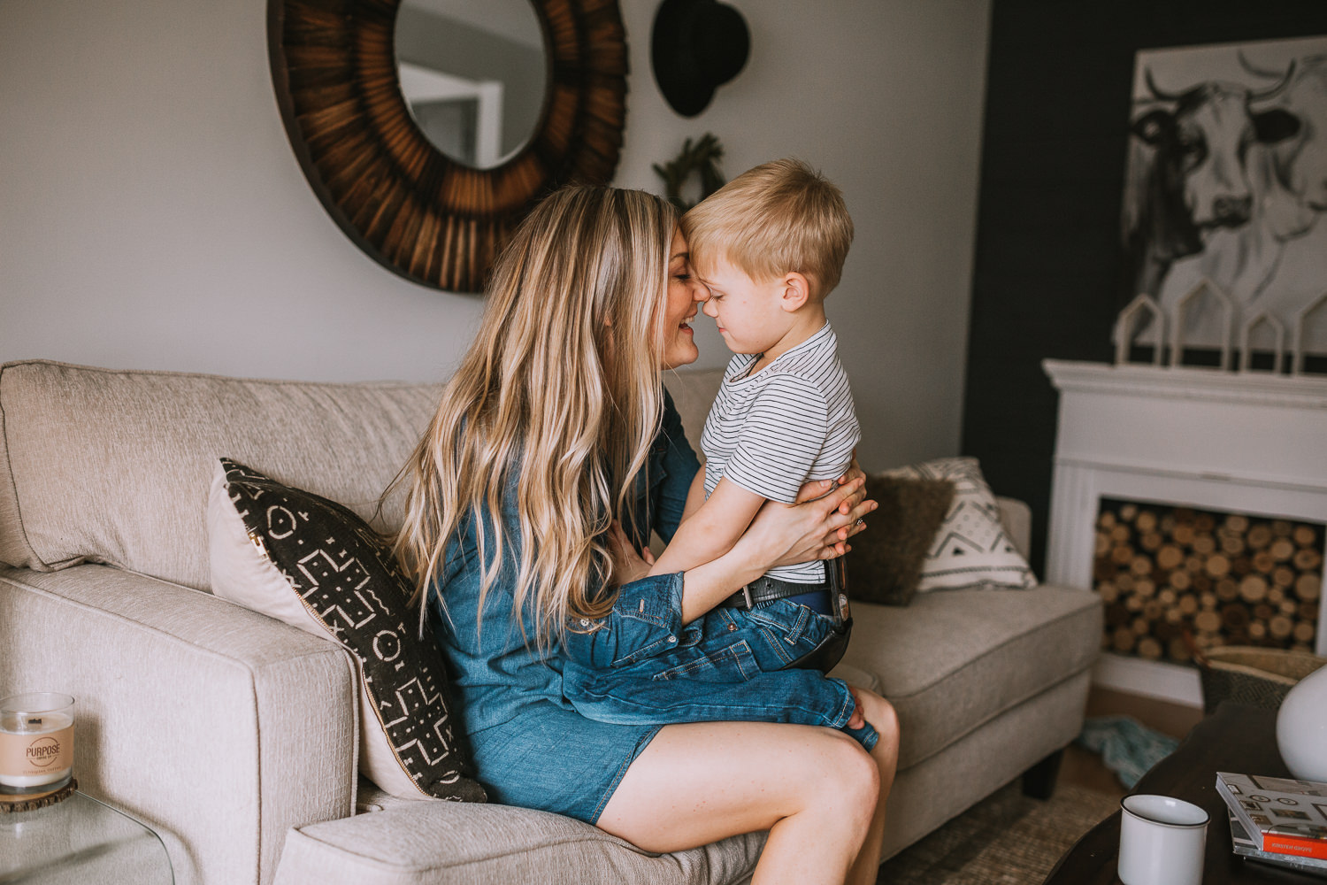 mom with long blonde hair holds 4 year old son in lap touching foreheads - Stouffville child photography