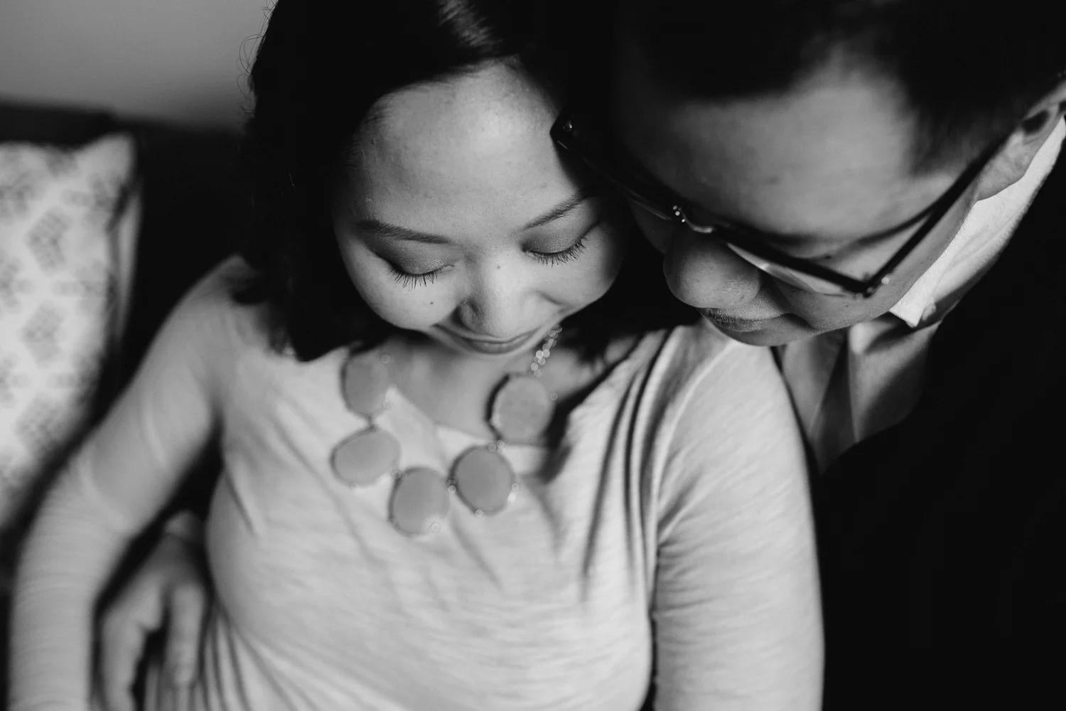 couple expecting first baby snuggle on couch - Uxbridge in-home photography