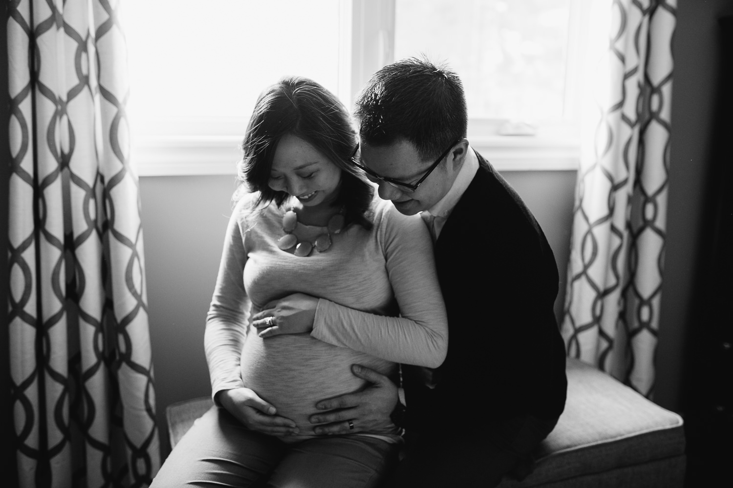 couple expecting first baby looking at pregnant mom's belly - Uxbridge in-home photography