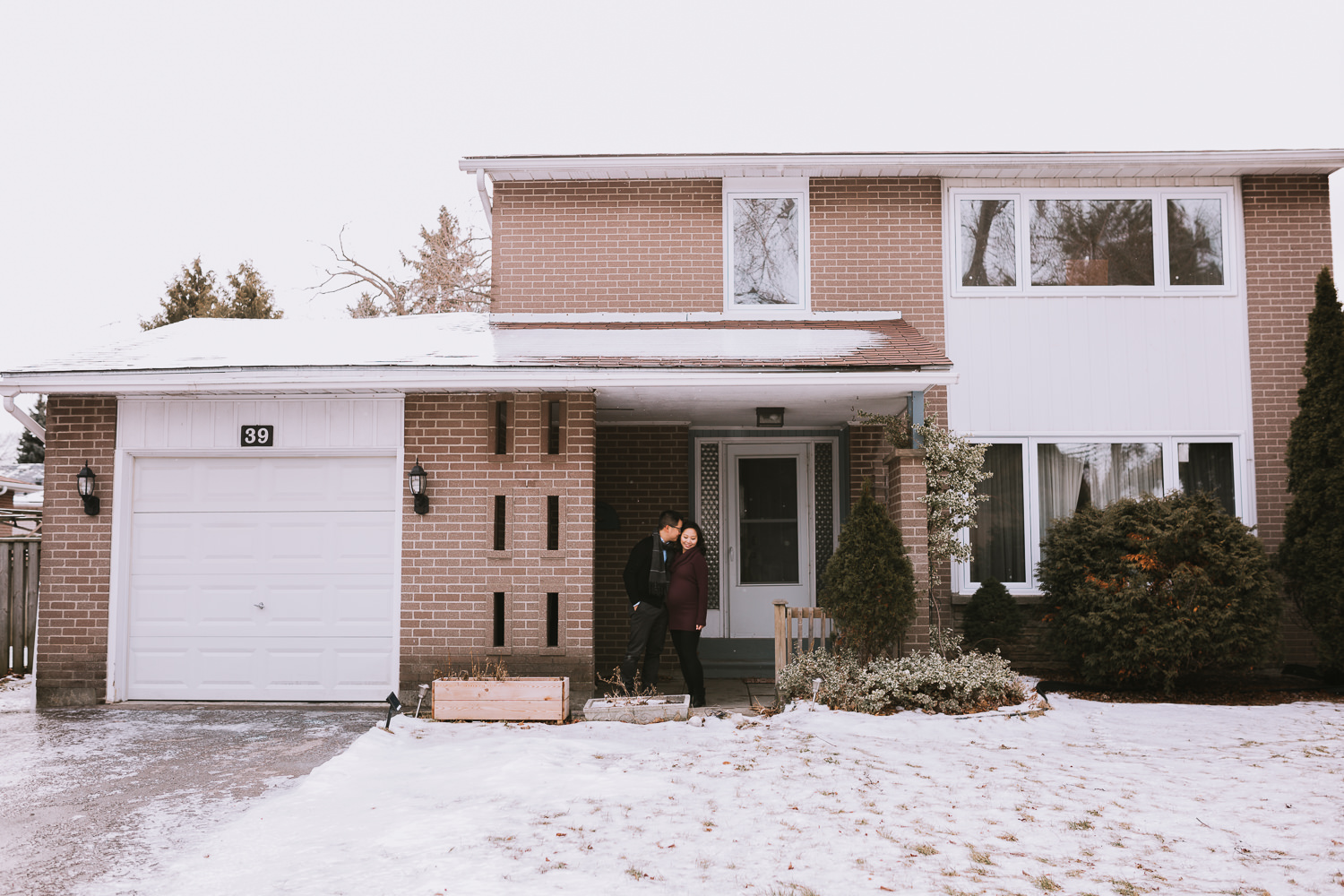 couple expecting first baby in front of first home - Newmarket lifestyle photography