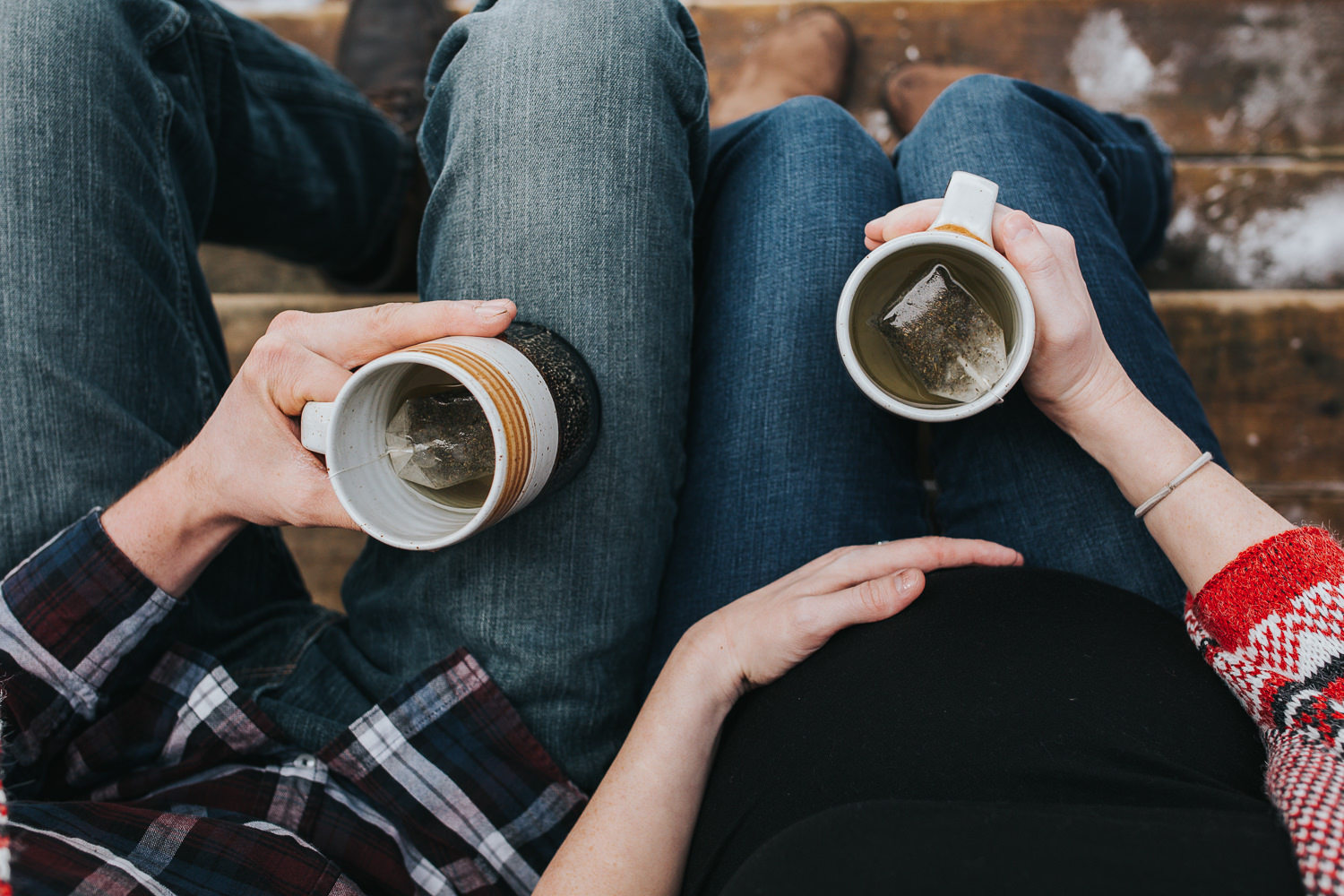 husband and wife holding mugs of tea, mom's hand on baby belly - Newmarket lifestyle photos