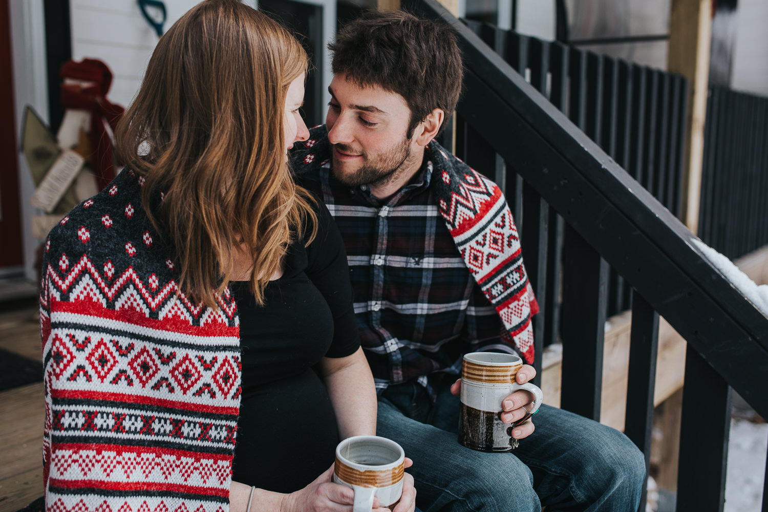 parents to be sitting on front porch steps wrapped in blanket looking at one another  - Stouffville lifestyle photography