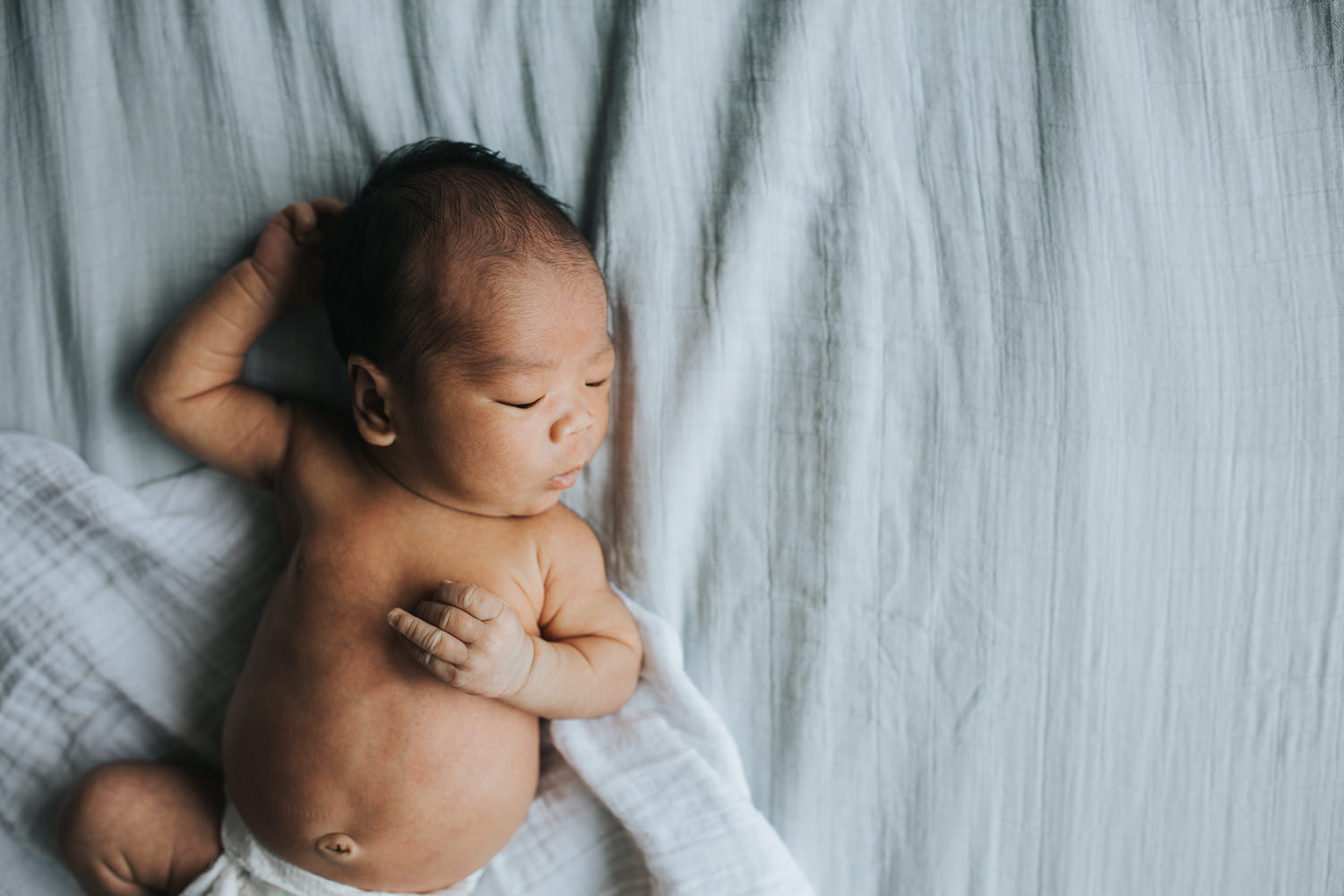 newborn baby boy sleeping and lying on bed - Newmarket lifestyle photography