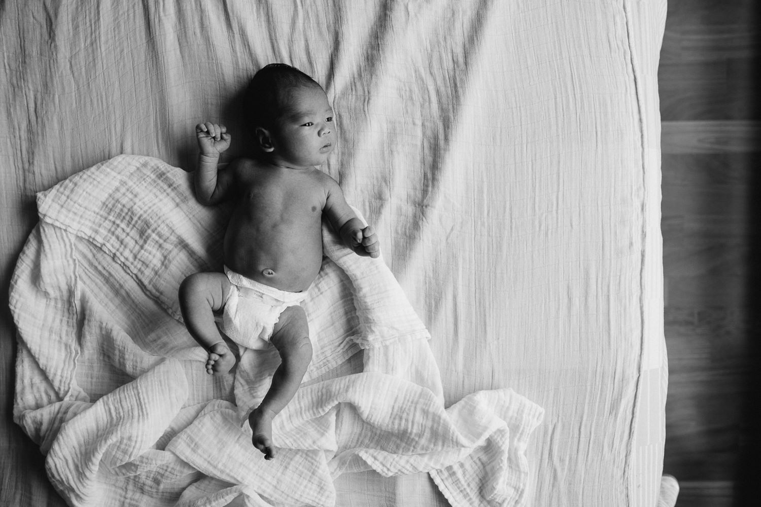 newborn baby boy with dark hair lying on bed - Stouffville lifestyle photography