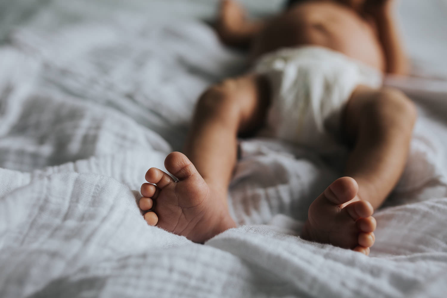 2 week old baby boy lying on bed, close up of feet - Newmarket in-home photography