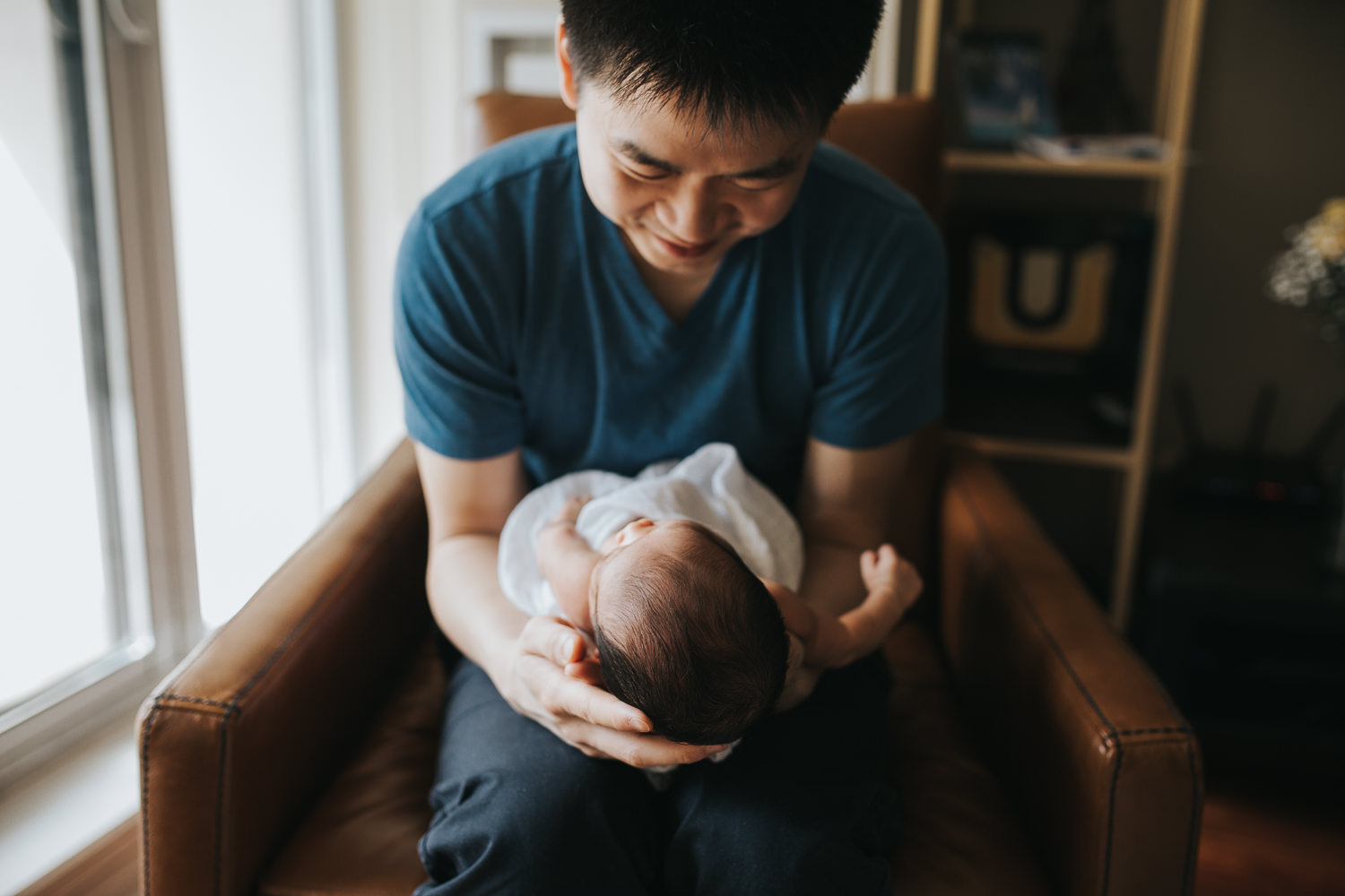 first time dad holding and smiling at 2 week old baby boy - Barrie in-home photography