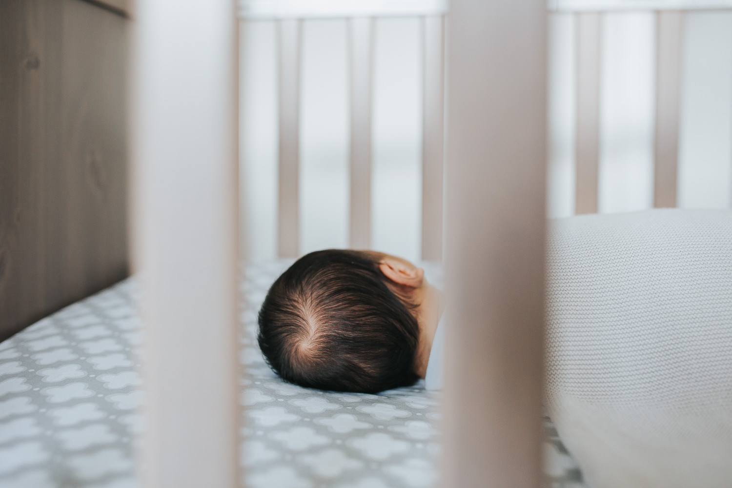 2 week old baby boy with dark hair sleeping in nursery crib - Markham lifestyle photos