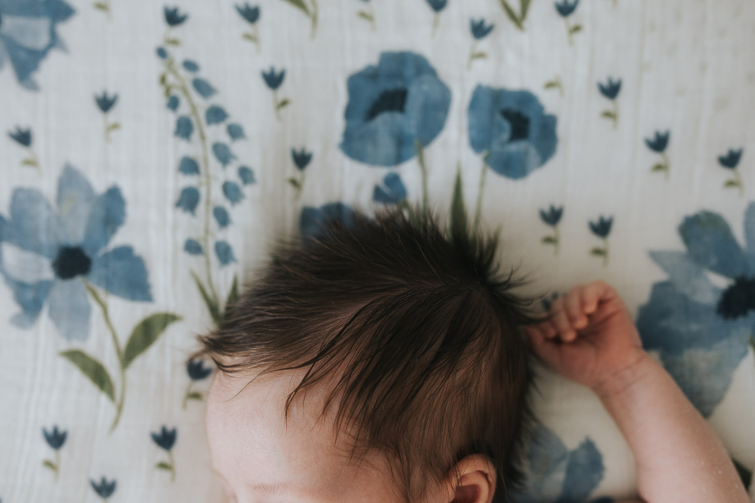 2 week old baby girl with lots of dark hair lying on bed - Newmarket lifestyle photography