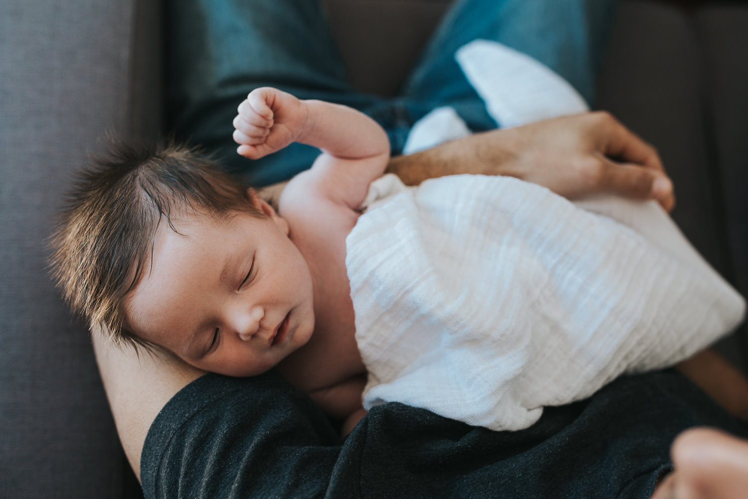 2 week old baby girl with lots of dark hair sleeping in father's arms - Markham lifestyle photos