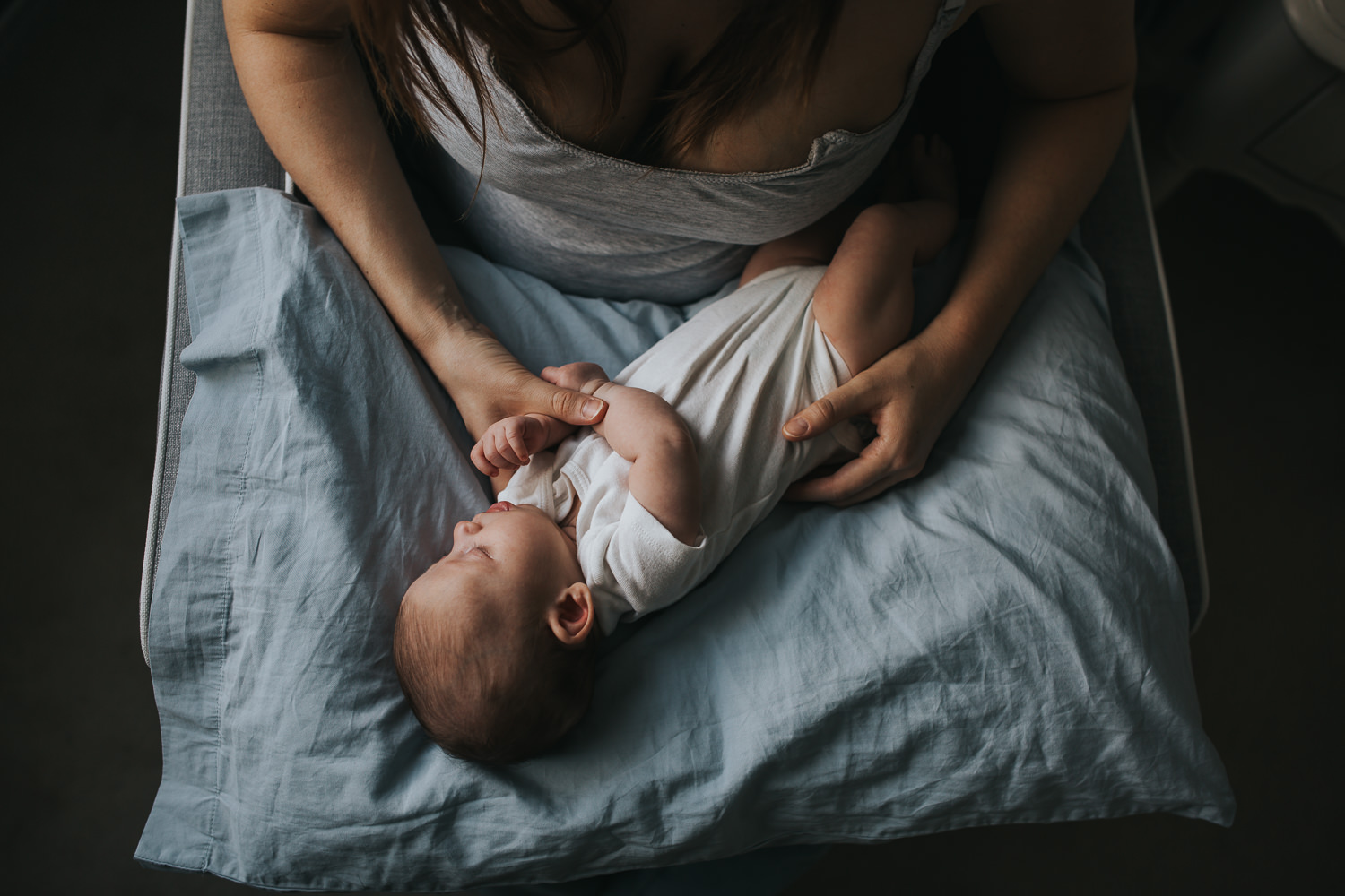 6 week old baby girl asleep on nursing pillow in mother's lap - Barrie in-home photography 