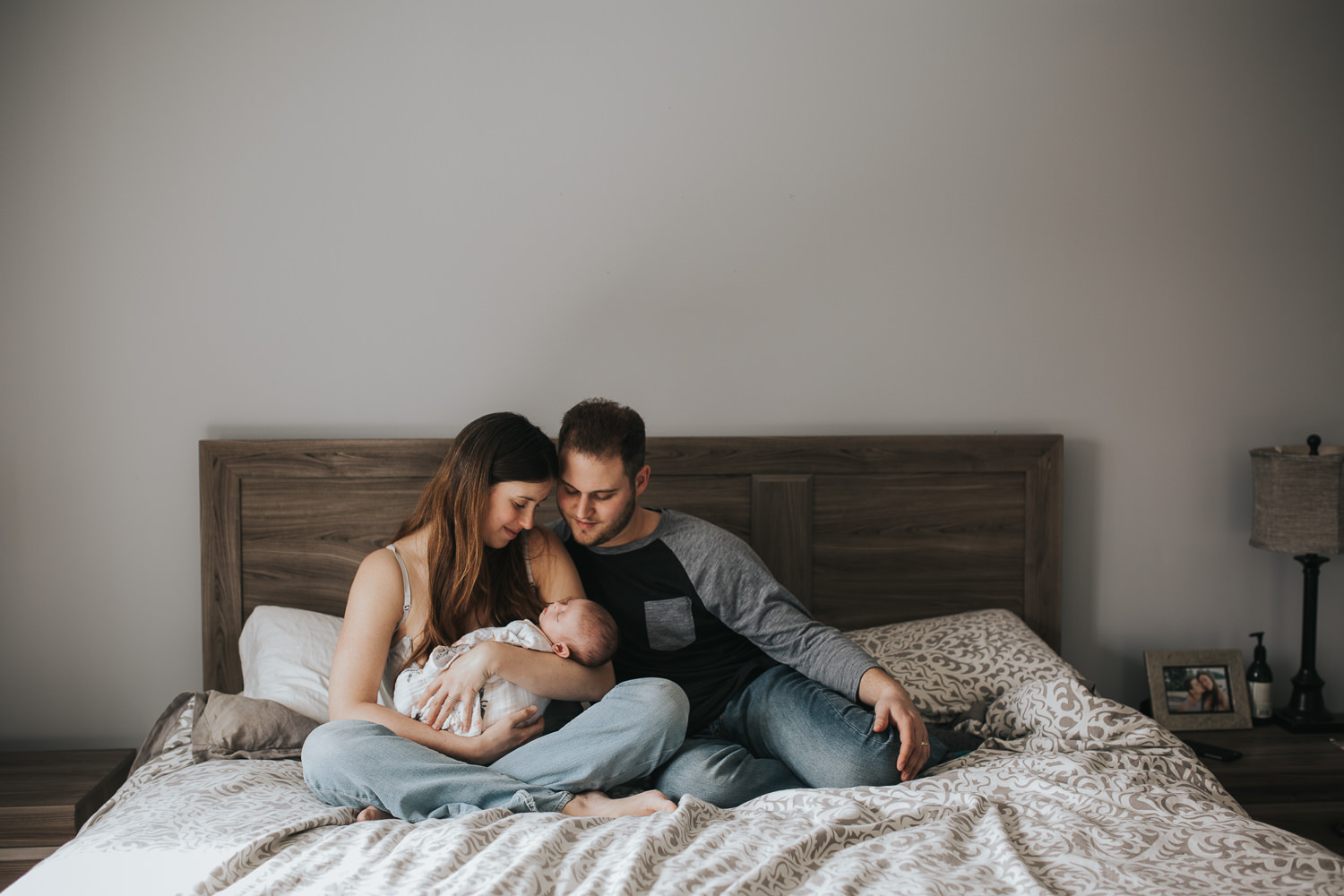 mom and dad snuggling 6 week old baby girl in bed - Newmarket in-home photography