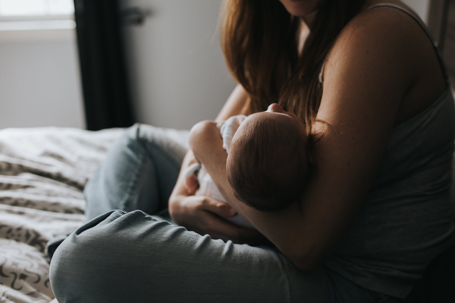 new mom snuggling 6 week old baby girl in bed - Markham in-home photography