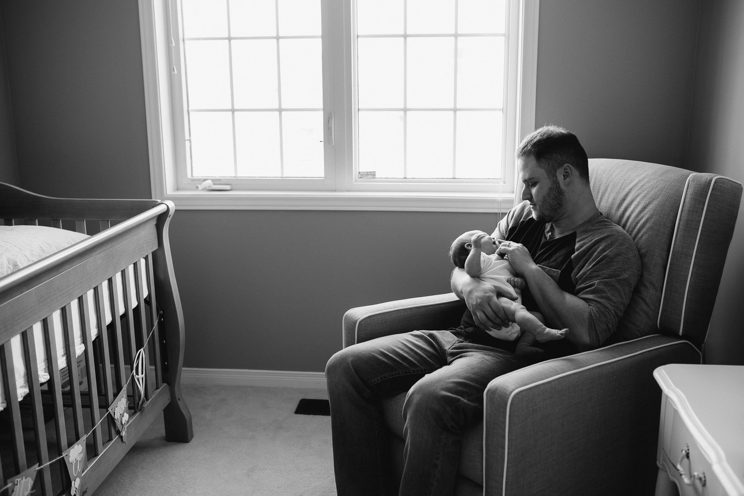 new dad holding 6 week old baby daughter in nursery glider - Stouffville lifestyle photos