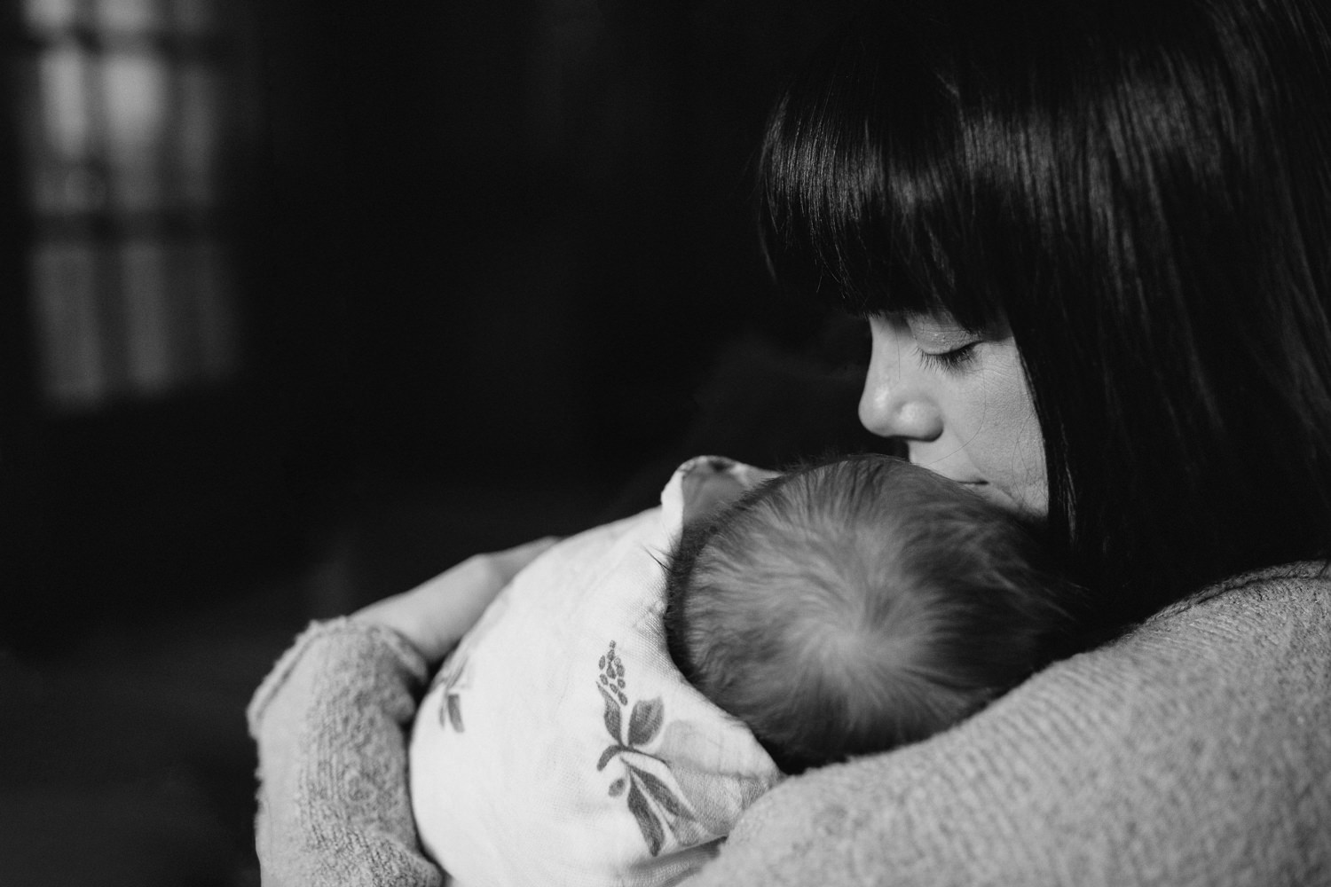 brunette mother holds 5 week old swaddled, sleeping baby girl - Stouffville lifestyle photography