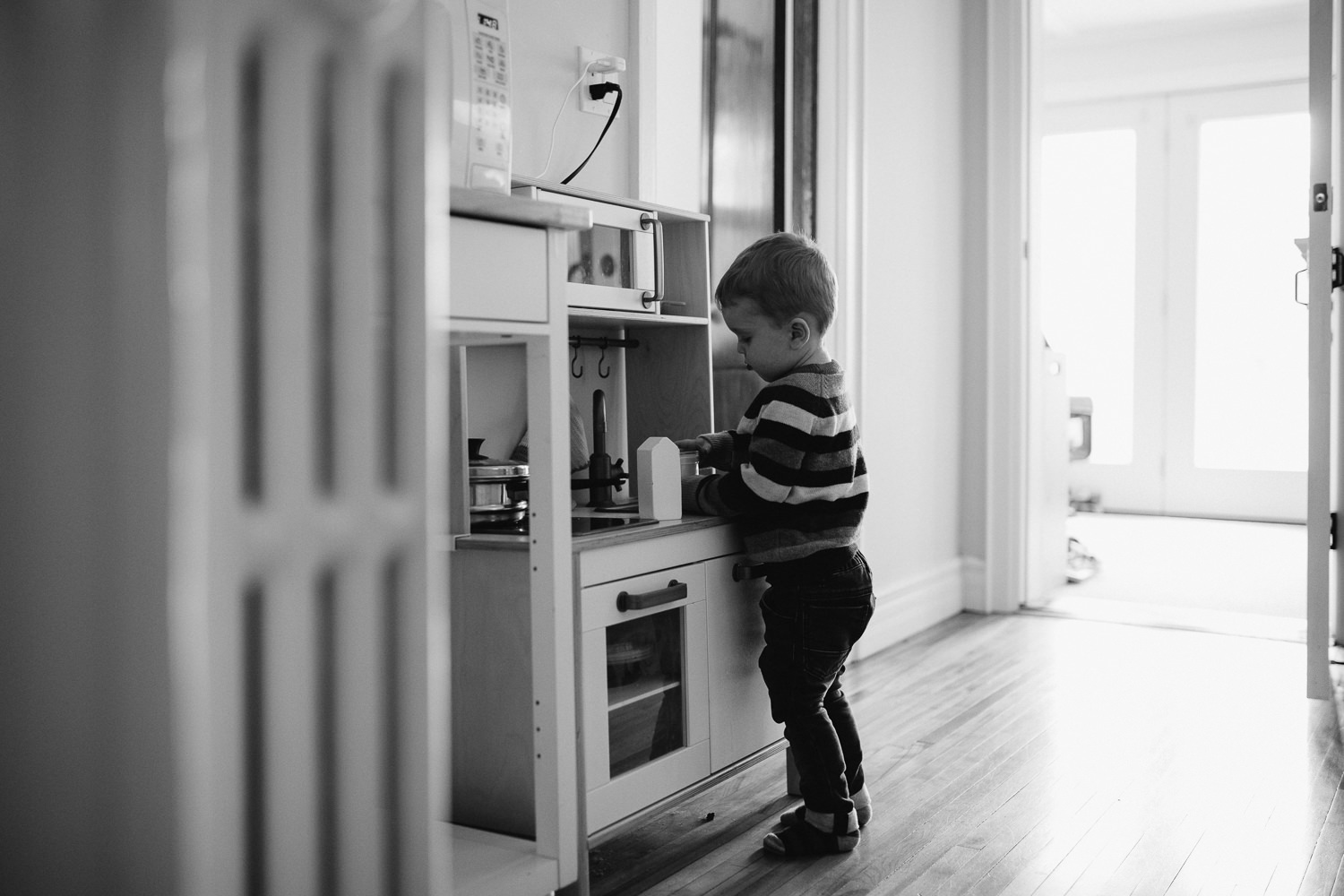 3 year old toddler boy plays with toy kitchen - Barrie in-home photography 