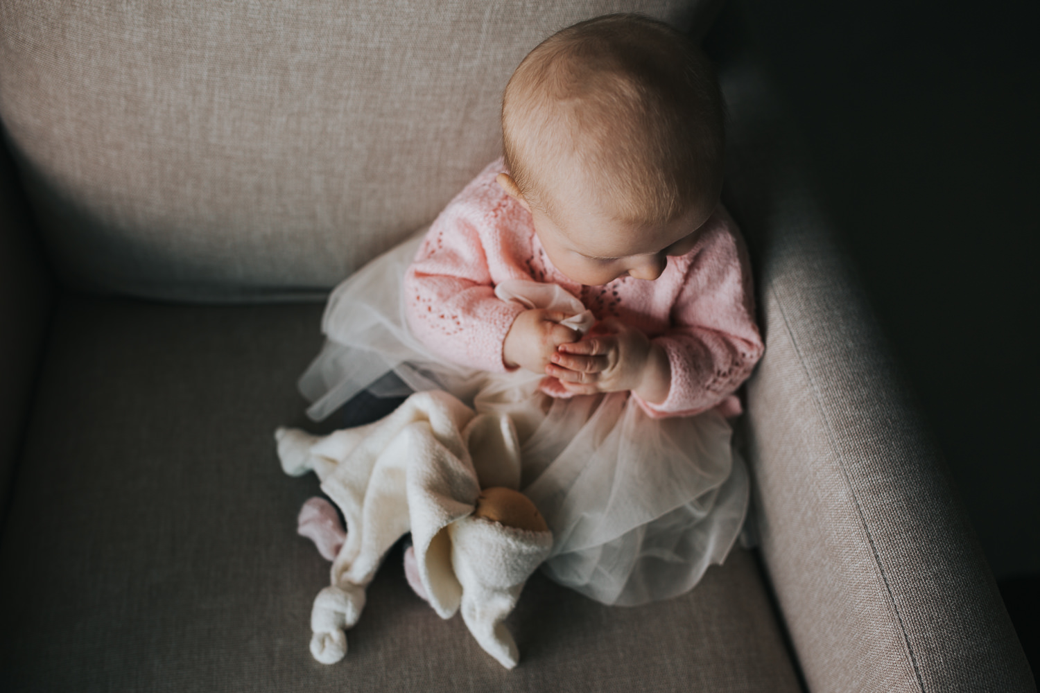 5 month old baby girl in pink sweater sitting on chair with stuffed toy - Barrie lifestyle photography