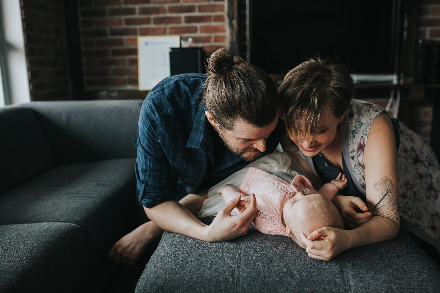 parents looking and smiling at 5 month old baby girl lying on couch - Stouffville lifestyle photography
