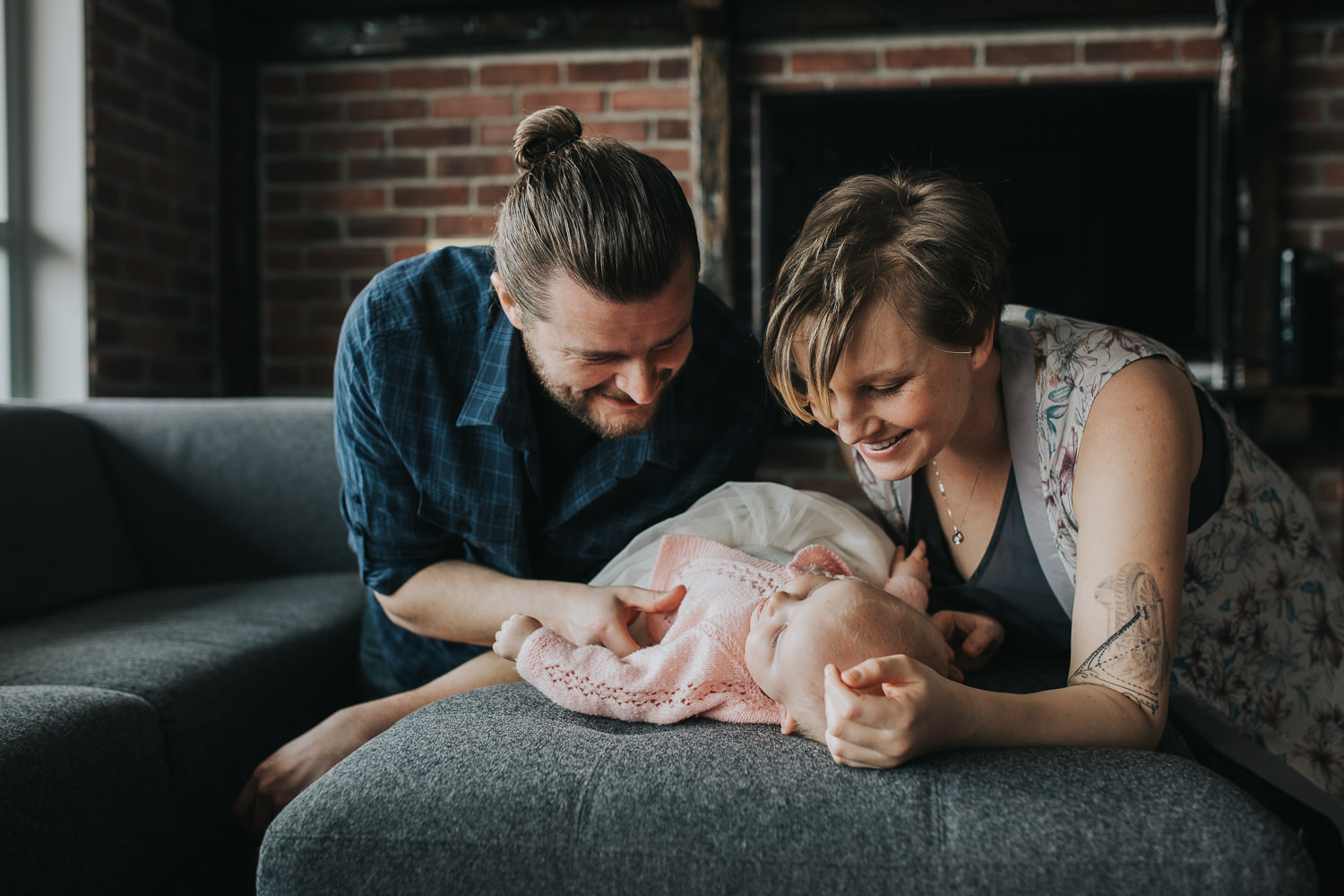parents looking and smiling at 5 month old baby girl lying on couch - Newmarket lifestyle photography