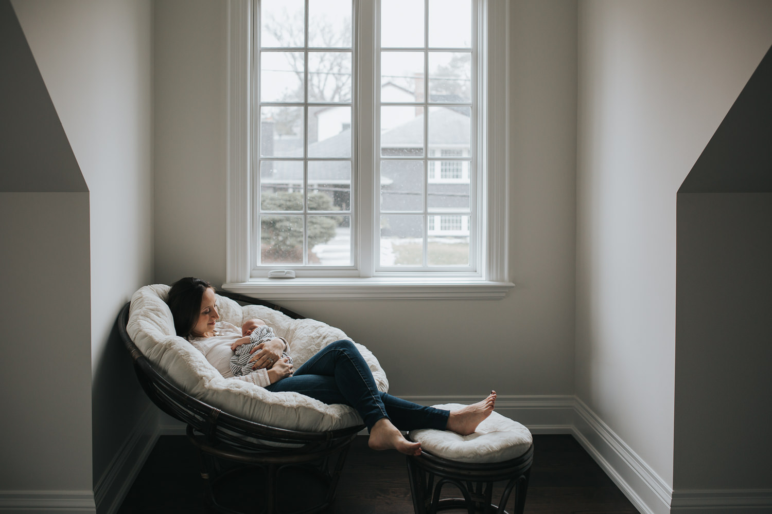 mother lying in chair with feet up, holding 2 week old baby boy - Markham in-home photography 