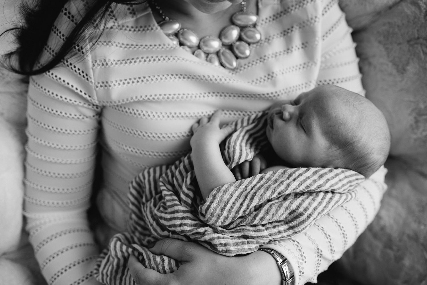 2 week old baby boy asleep in mother's arms - Barrie in-home photography 