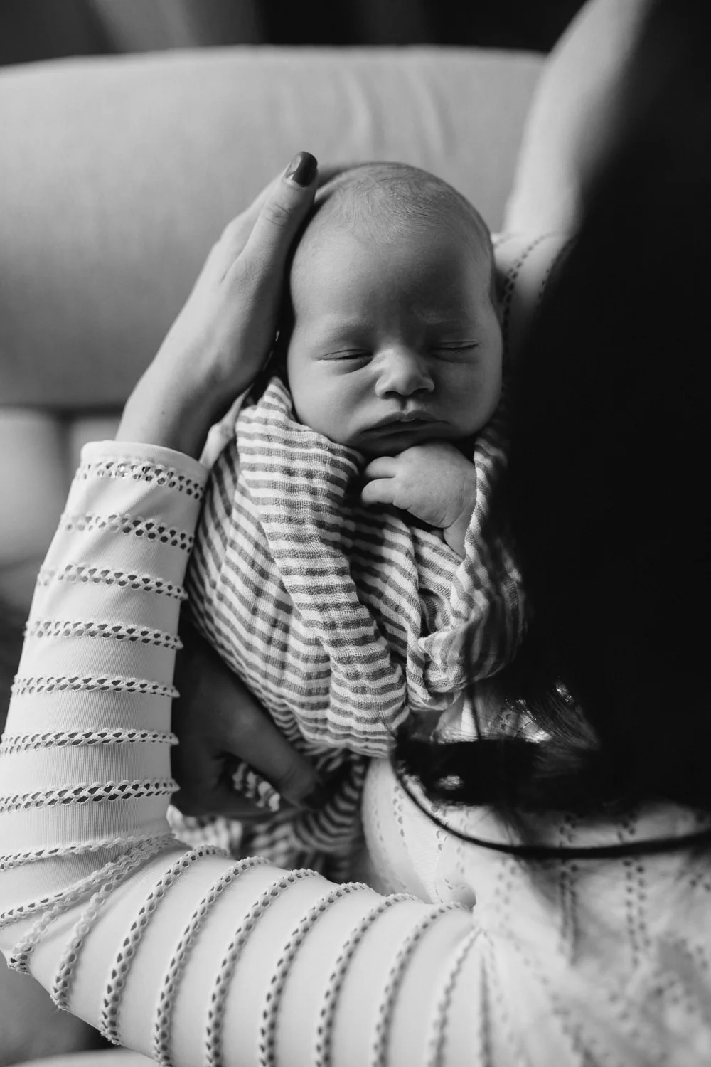 2 week old baby boy asleep with hand under chin, lying on mother's arms - Newmarket lifestyle photography