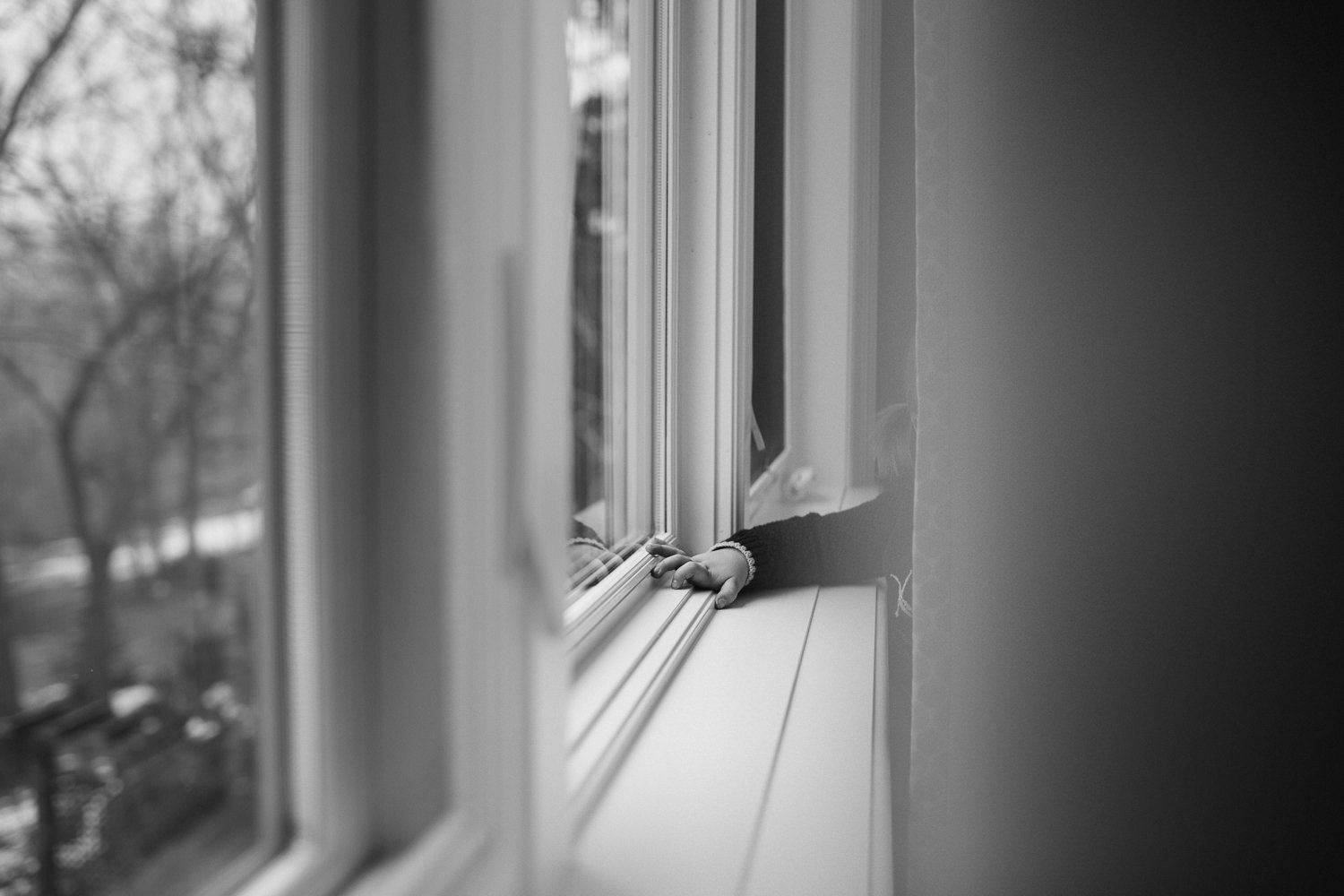 2 year old toddler girl's hand reaching through curtains, resting on windowsill - Markham lifestyle photography