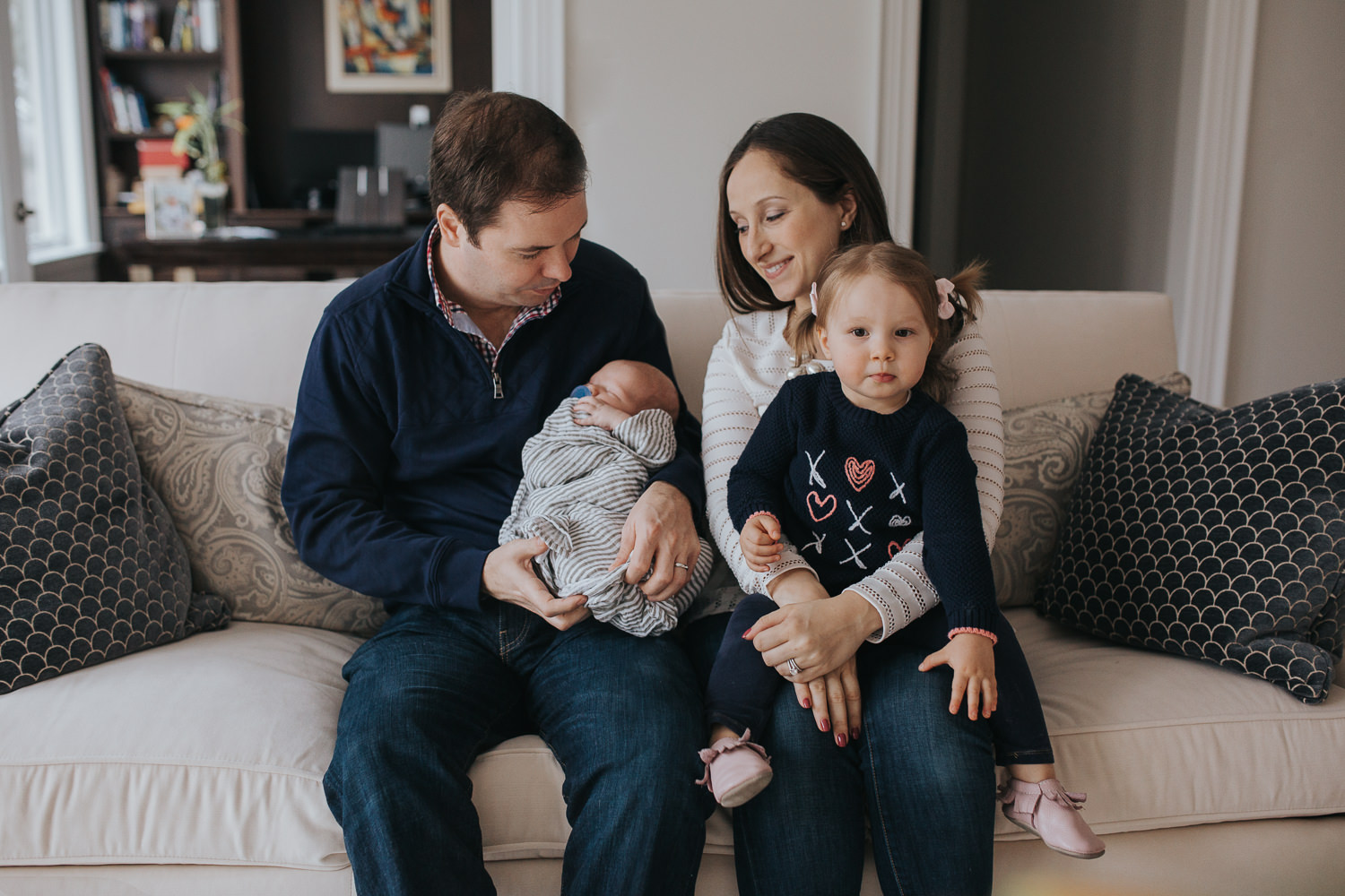 family of 4 sitting on couch with 2 week old baby boy and 2 year old toddler girl - Stouffville in-home photos