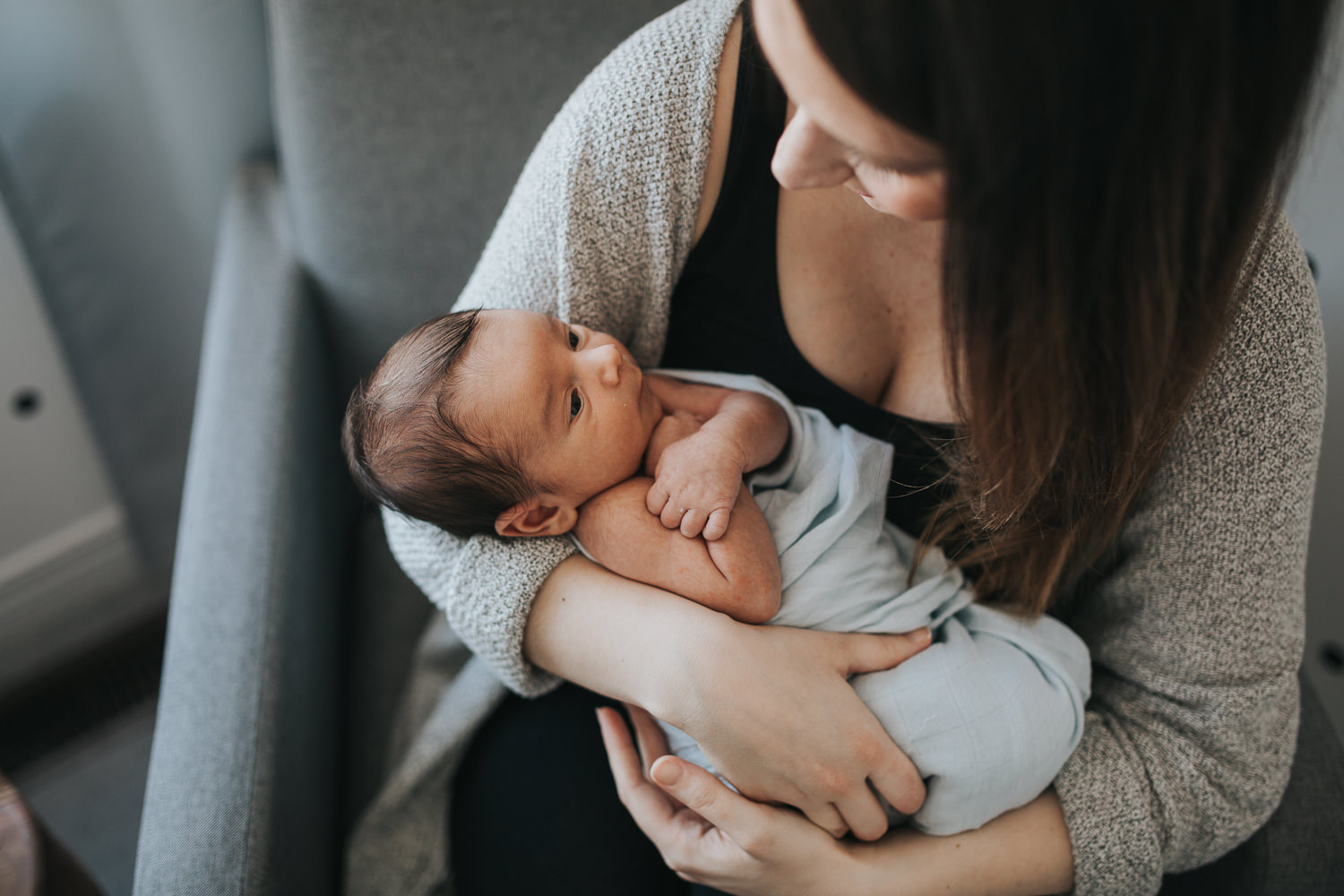 2 week old baby boy in mother's arms looking at mom - Newmarket Lifestyle Photography