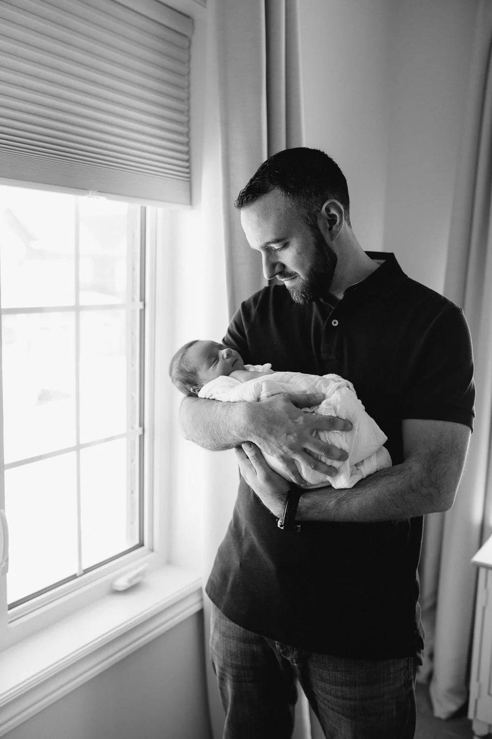new dad holding and looking at sleeping 2 week old baby boy - Stouffvillein-home photography