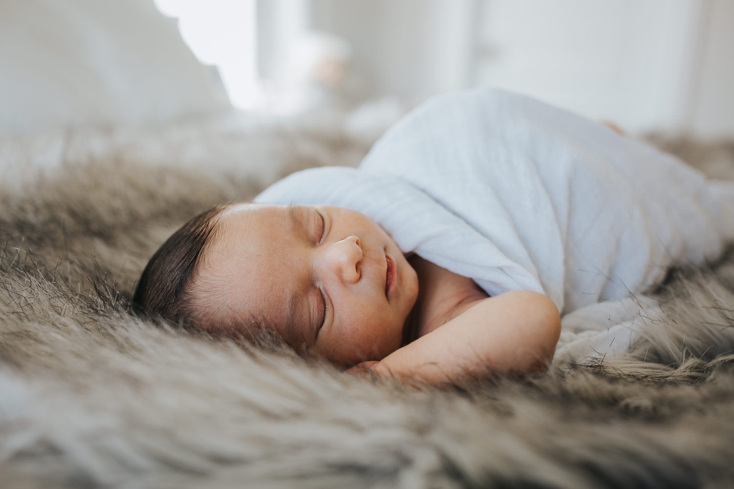 2 week old baby boy asleep on parent's bed in white swaddle - Newmarket lifestyle photos 