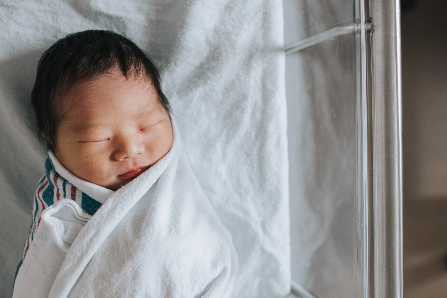 1 day old baby boy sleeping swaddled in hospital bassinet - Newmarket Fresh 48 photography
