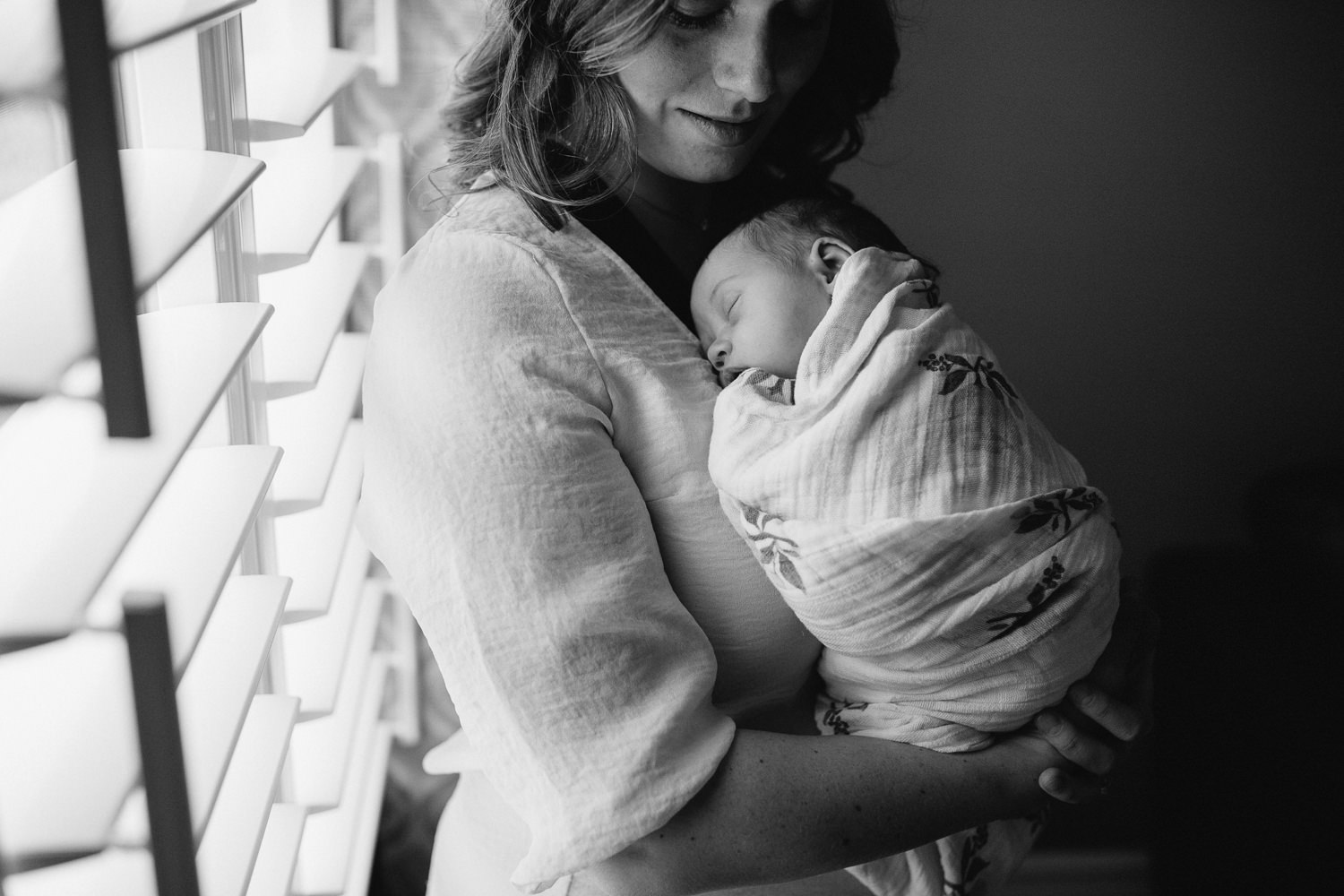 new mother snuggles sleeping, swaddled 2 week old baby daughter to chest - Newmarket Lifestyle Photography