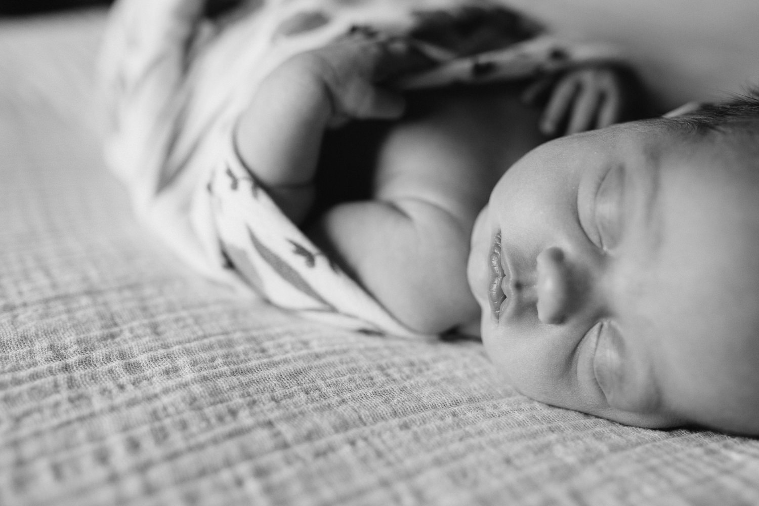2 week old baby girl in swaddle lying asleep on bed - Barrie Lifestyle Photos