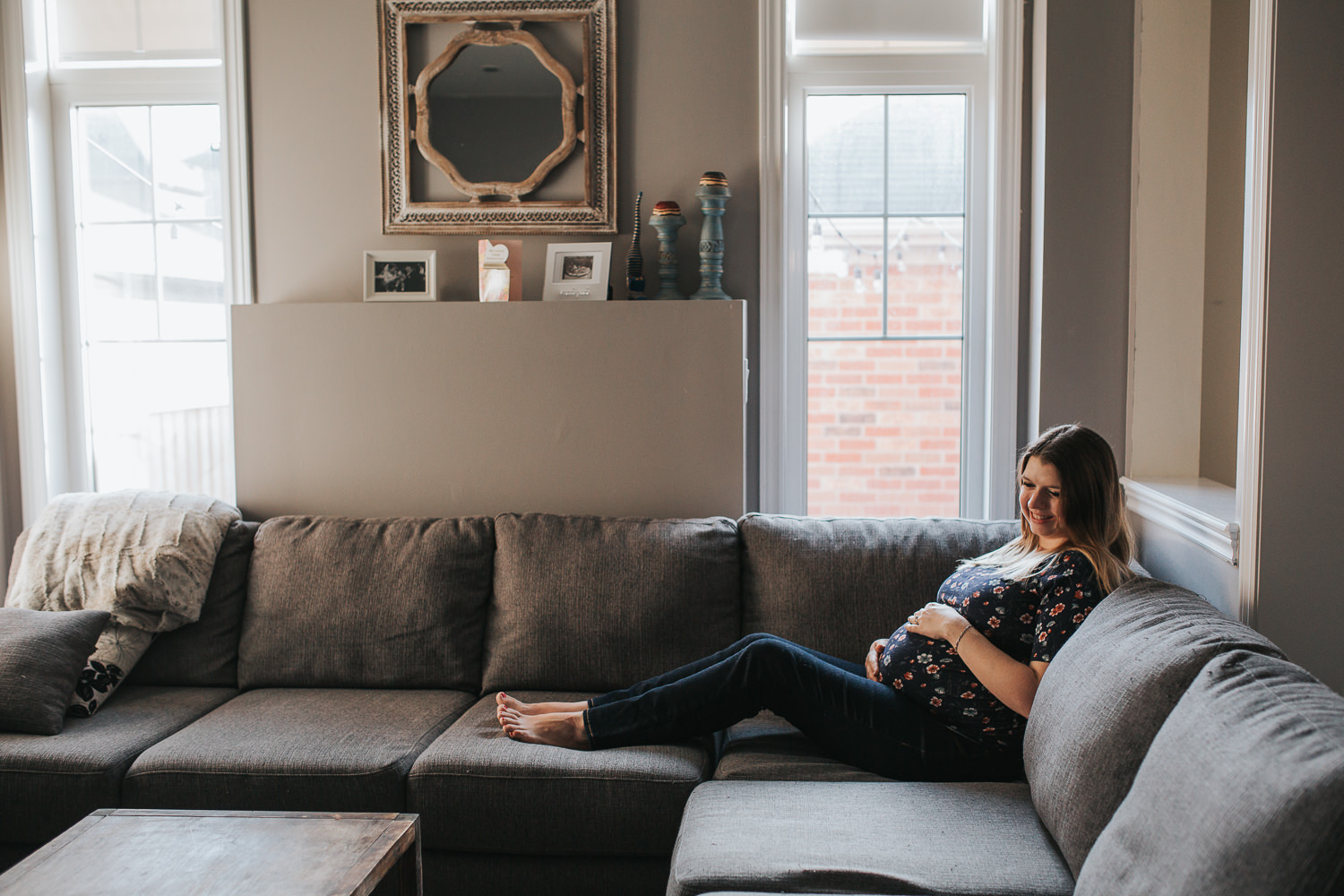 pregnant mother-to-be sitting on couch, holding baby belly - Barrie Lifestyle Photography