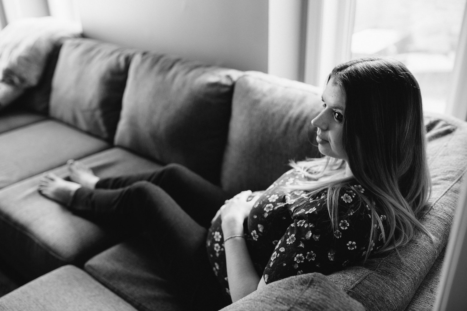 pregnant mother-to-be sitting on couch, holding baby belly - Uxbridge Lifestyle Photography