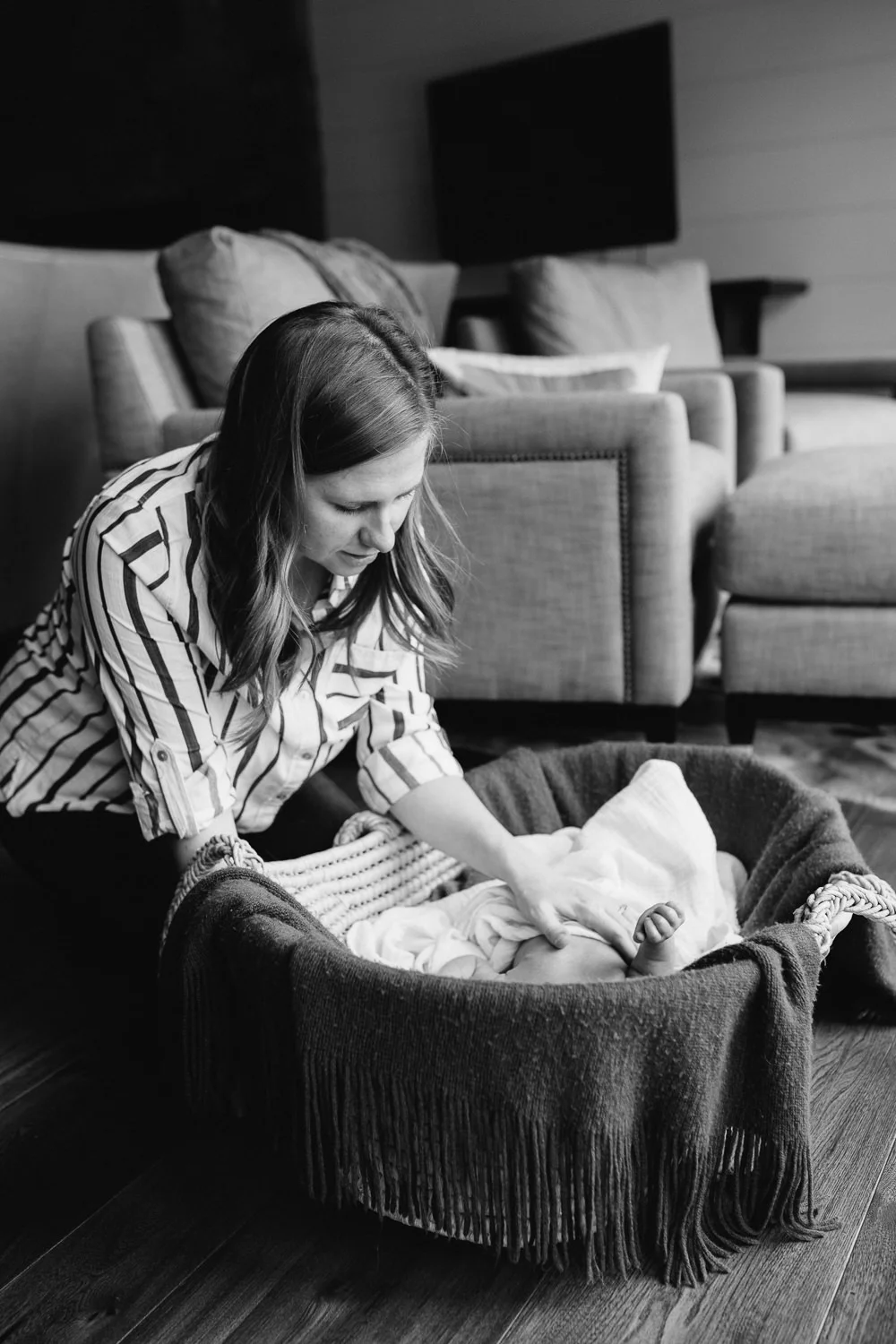 new mom looks at 2 week old baby son lying in Moses basket - Uxbridge In-Home Photos