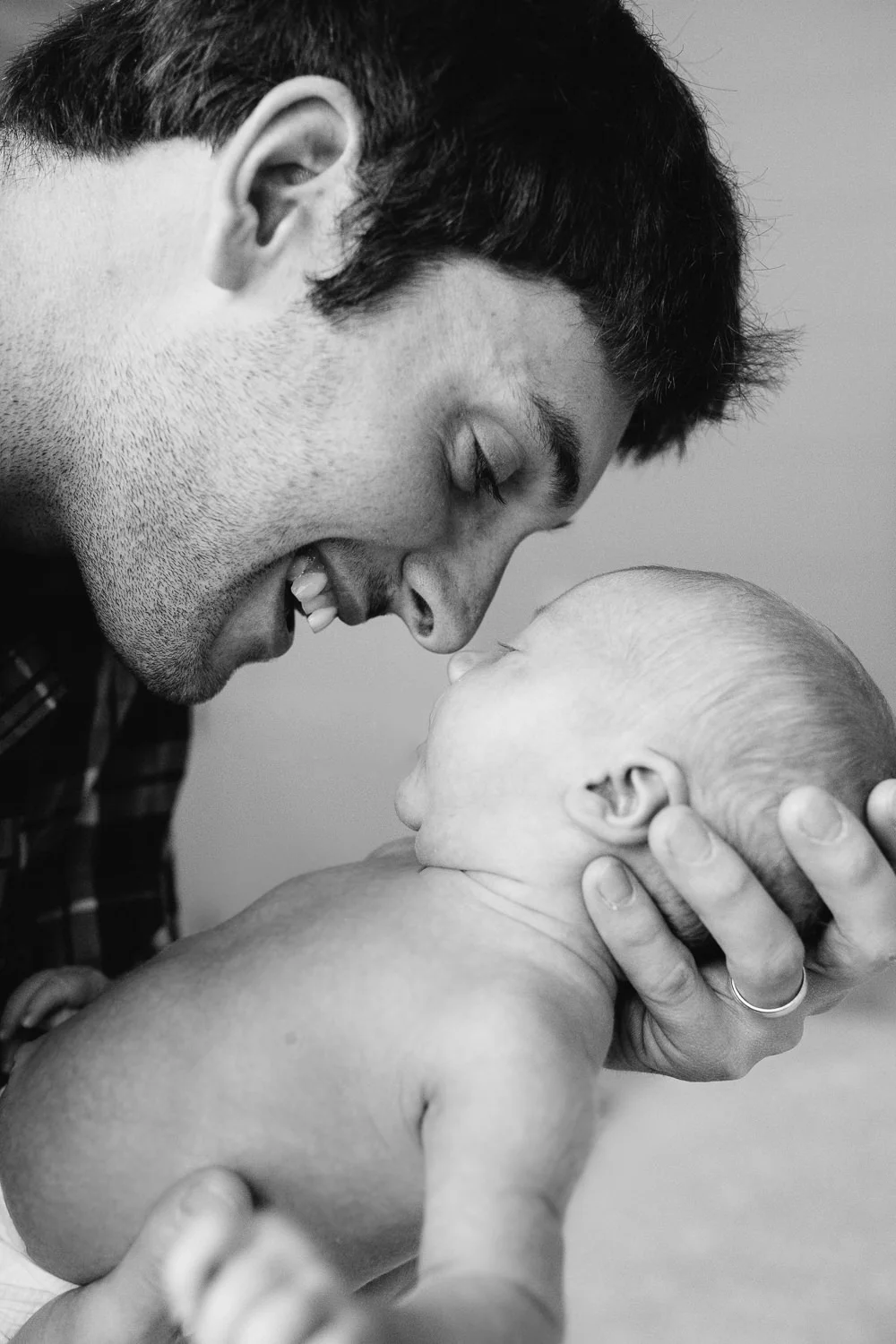 new dad smiling and touching noses with 2 week old baby son - Newmarket Lifestyle Photography