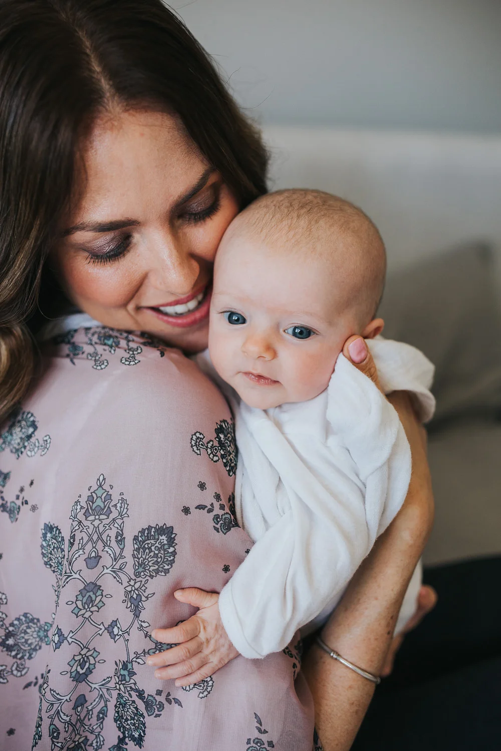 new mother holds 2 month old baby daughter in white onesie over shoulder - Markham Lifestyle Photos