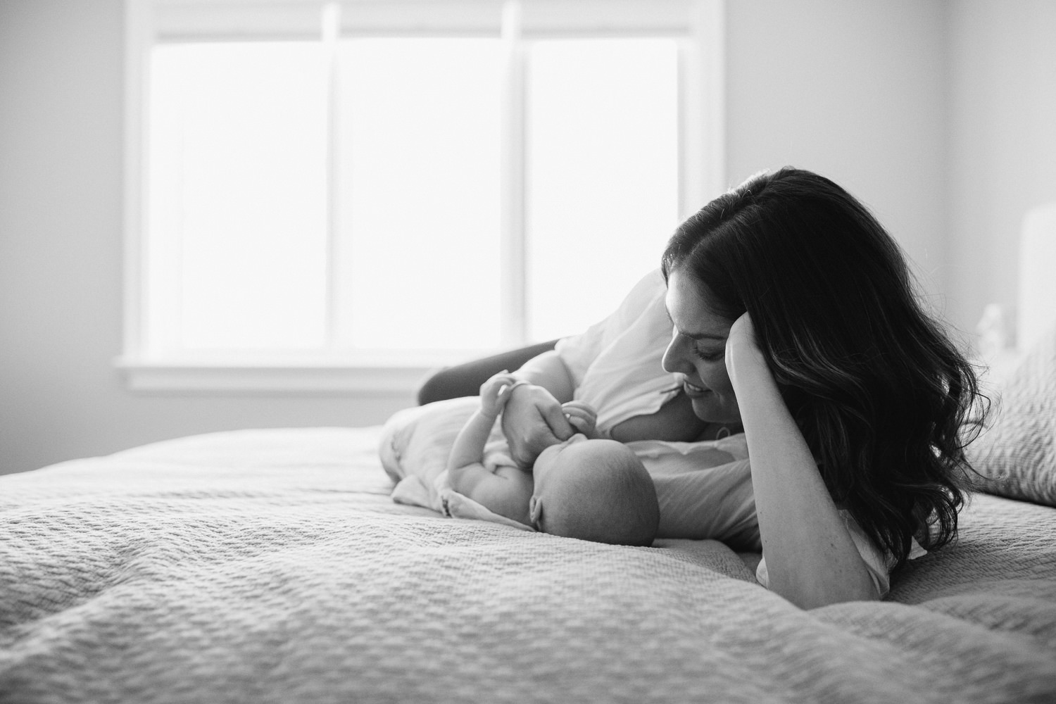 new mother lying on bed snuggling 2 month old baby daughter - Markham Lifestyle Photography