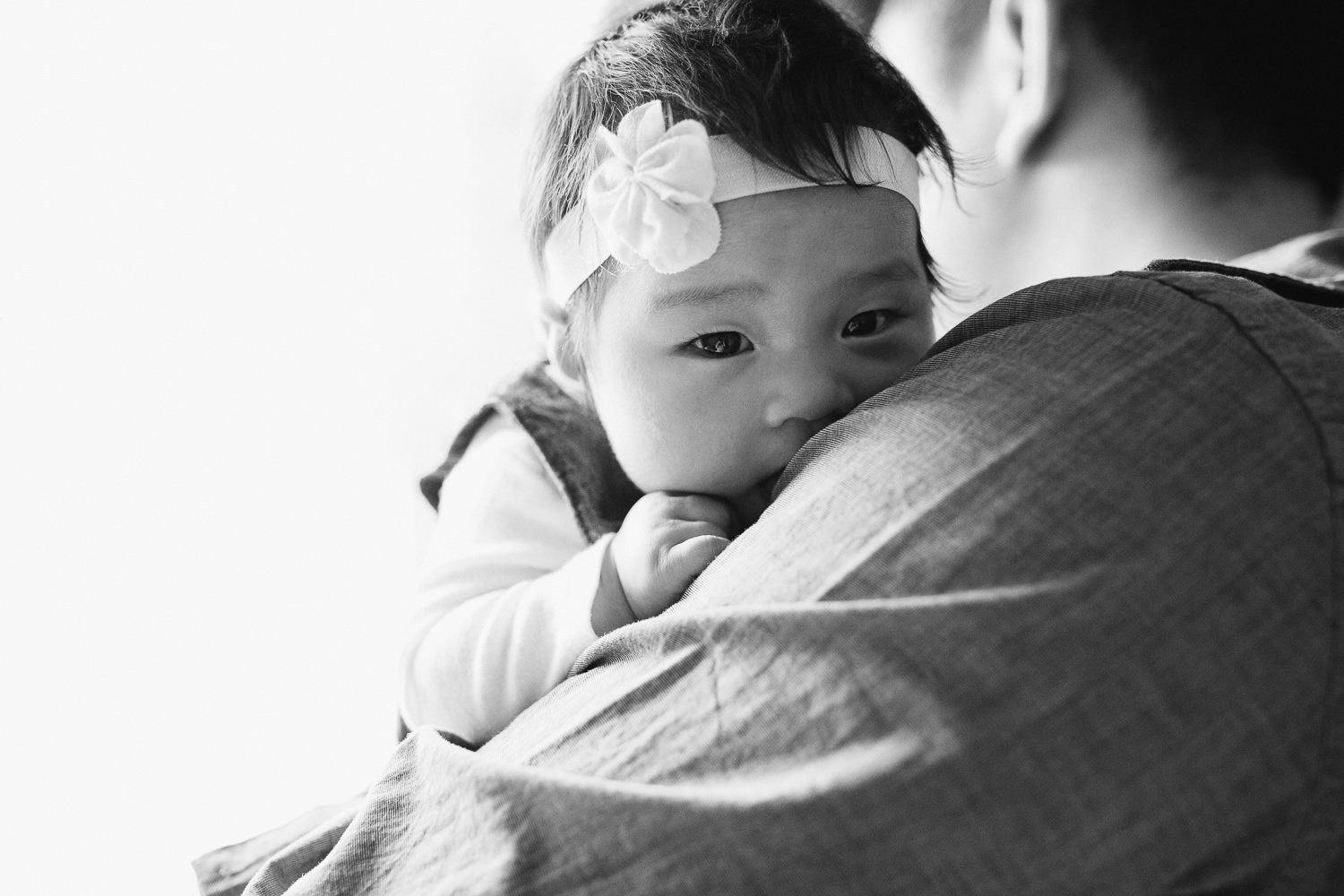 3 month old baby girl looking at camera over dad's shoulder - Uxbridge Lifestyle Photography